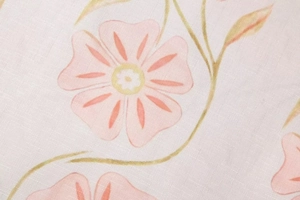 Détail du tissu à imprimé floral rose avec texture croisée et douces feuilles vertes