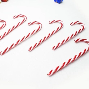 Close-up of six red and white striped candy cane ornaments for Christmas tree decor