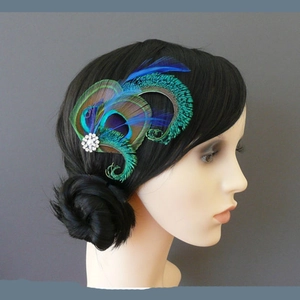 Detail of elegant peacock feather hair clip with sparkling rhinestones and pearls