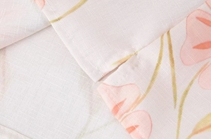 Gros plan sur tissu en lin à fleurs roses montrant la couture et la fente latérale