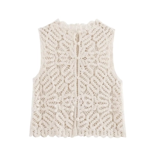 Detailed view of white crochet knit vest featuring hollow patterns and small button closure