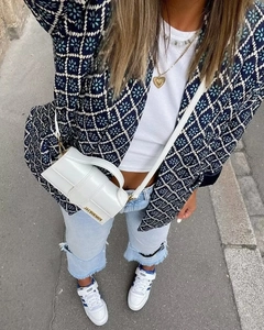 Draufsicht auf eine marineblaue gesteppte Blumenjacke mit weißem T-Shirt und Jeans