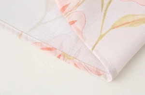 Vue macro de l'imprimé floral rose et de la texture du tissu avec détails de couture sur la robe