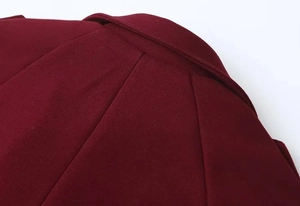 Detail of the elegant lapel collar and rich burgundy wool fabric on a women's coat