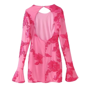 Détail de la broderie florale et des manches évasées sur la robe de soirée rose