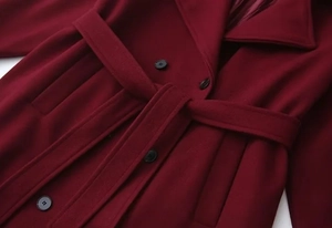 Detailed close-up of wine red wool coat featuring a notched lapel and black buttons
