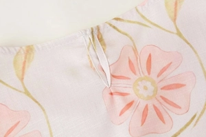 Détail de l'imprimé floral rose sur robe sans manches en coton lin avec texture