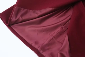 Detail of wine red woolen coat showing thick outer fabric and smooth satin lining texture