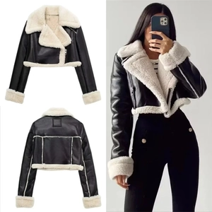 Close-up of women's black faux leather cropped biker jacket with thick white shearling trim