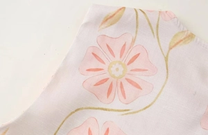 Gros plan détaillé de motifs floraux roses et de la texture lin naturel d'une robe