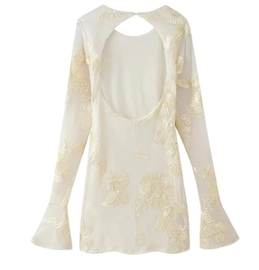 Détails de la robe ivoire avec broderie florale, manches cloches et dos nu profond