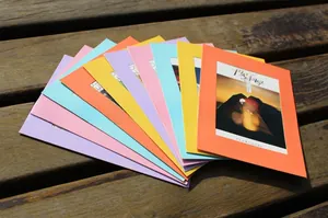 Close-up of colorful paper photo frames with graduation text on outdoor wooden background