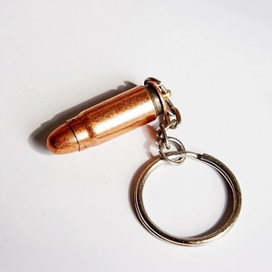 Detailed macro shot of a bullet-shaped metal keychain with copper finish and silver ring