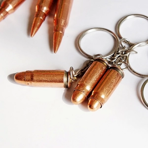 Close-up of metallic bullet-shaped pendants with keychains in copper finish