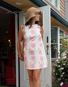 Détail de l'imprimé floral rose sur une robe sans manches en coton et lin blanc