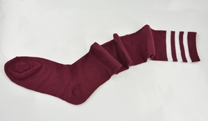 Flat lay of burgundy knit over-knee socks featuring classic white triple stripes detailing