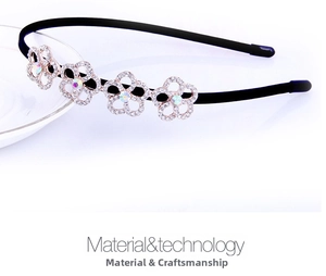 Detail of slim black headband with four rhinestone-studded silver metal flower accents