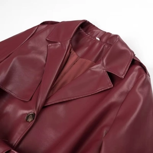 Detail of burgundy PU leather coat showing lapel collar, epaulet, and premium texture