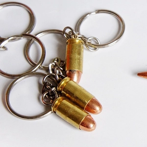 Detailed view of heavy-duty metal bullet shaped keychains with realistic bronze finish