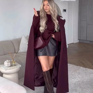 Detail of burgundy wool coat with lapel collar paired with leather skirt and tall boots