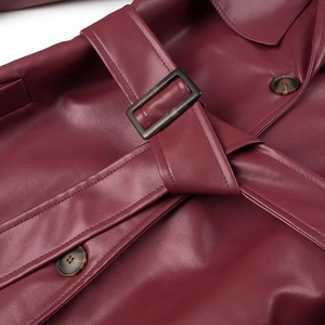 Macro shot of burgundy faux leather texture with belt buckle and marble button detail