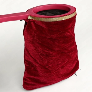 Close-up of red velvet magic trick bag with gold trim, purple handle and hidden zipper detail