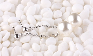 Detail of silver long tassel earrings with white pearls on smooth white stones
