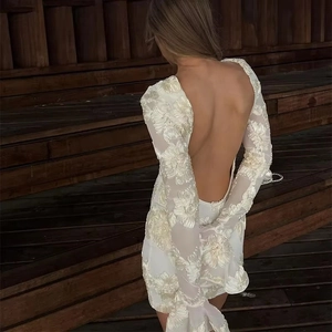 Détails du dos d'une mini robe blanche en dentelle brodée avec design dos nu élégant