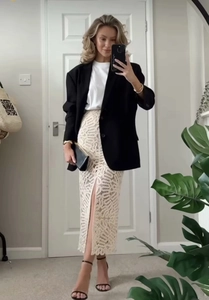 Close-up of beige crochet midi skirt featuring a stylish front slit and intricate patterns