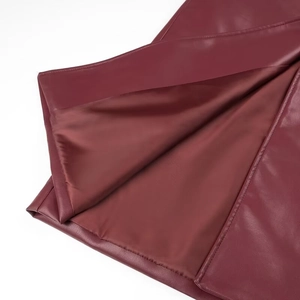 Macro detail of wine red matte leather jacket with smooth matching satin lining
