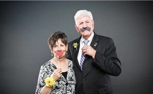Couple holding red lips and black mustache photo booth props for cinema party events