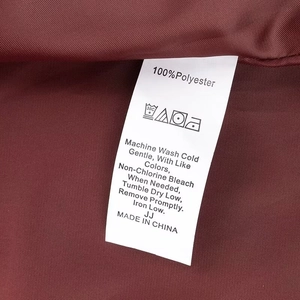 Gros plan sur l'étiquette d'entretien indiquant 100% polyester et conseils de lavage