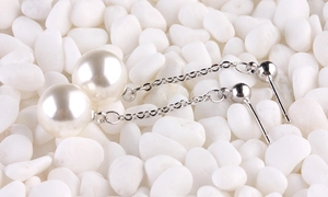 Detailed view of silver long chain tassel earrings with glossy white pearls on pebbles