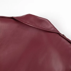 Macro detail of wine red leather coat collar with lychee texture and metal shoulder studs