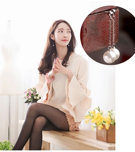 Detailed view of elegant long silver chain earrings with glossy white round pearls