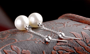 Macro view of long pearl tassel earrings featuring S925 silver chains and round pearls