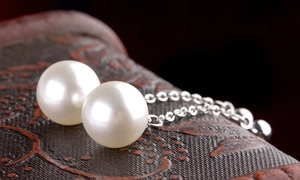 Close-up of elegant long tassel earrings featuring round white pearls and silver chains