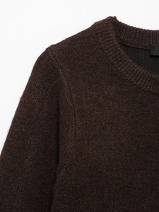 Close-up of ribbed crewneck and soft wool texture on dark brown knitted sweater