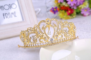 Close-up of golden Baroque tiara with sparkling rhinestones and a heart-shaped centerpiece