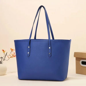 Royal blue lychee grain leather tote bag with silver rivets on minimalist shoulder strap