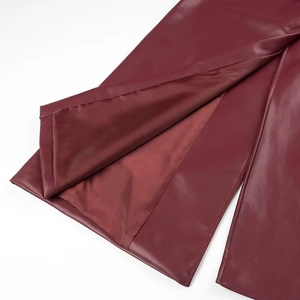 Detail view of wine red PU leather coat showing the slit design and smooth lining