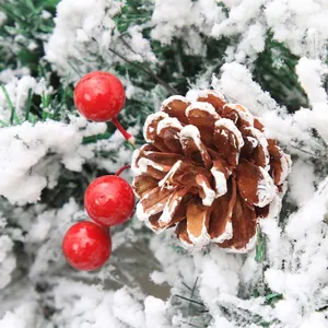 Christmas wreath with flocked pine needles, natural pine cones and red berries decoration