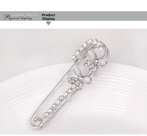 Detailed view of an elegant silver brooch with white cat-eye petals and clear rhinestones