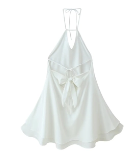 Detail of white halter dress featuring a large back bow and layered wave hem design