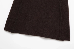 Macro shot of dark brown thick wool fabric texture with fine stitching on a knit skirt