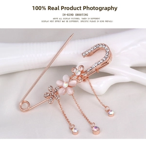 Close-up of a rose gold safety pin brooch with sparkling crystals and pink opal flowers