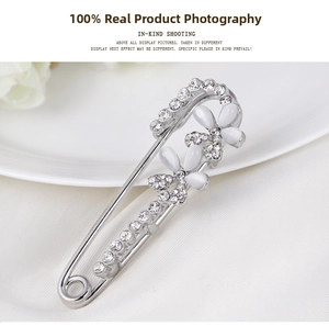 Detail of silver brooch with white floral gems and sparkling rhinestones on silk
