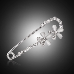 Elegant silver flower brooch with opal petals and crystals on a polished safety pin