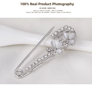 Detailed view of a silver floral bow brooch with sparkling crystals and white opals