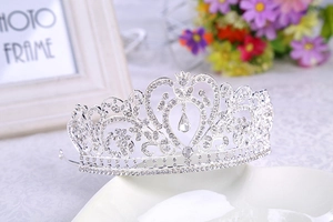 Macro shot of silver wedding crown with heart design and pear-shaped rhinestone drop